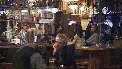 La gente se sienta en un bar en Estocolmo, el miércoles 25 de marzo de 2020. Las calles de la capital de Suecia son tranquilas pero no desiertas.