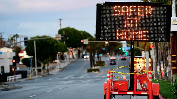 Panneau de signalisation routière recommandant indiquant "Plus en sécurité à la Maison" déployé dans les rues de Monterey Park en Californie, le 25 mars 2020. Panneau de signalisation routière recommandant indiquant "Plus en sécurité à la Maison" déployé dans les rues de Monterey Park en Californie, le 25 mars 2020.