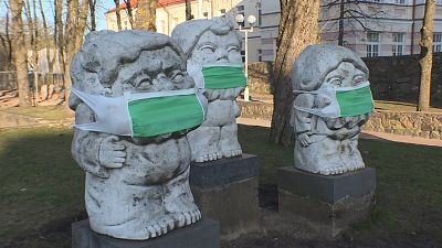 Litvánia: szájmaszk a komor szobrokon
