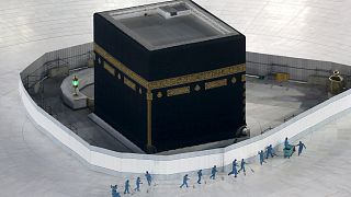 Workers disinfect the ground around the Kaaba, the cubic building at the Grand Mosque, in the Muslim holy city of Mecca, Saudi Arabia, Saturday, March 7, 2020