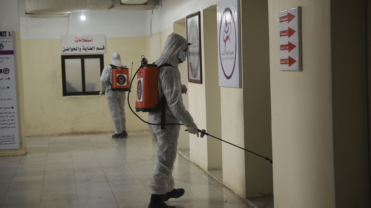 Members of a humanitarian aid agency disinfect Ibn Sina hospital as prevention against coronavirus in the city of Idlib, Syria, Thursday, March 19, 2020. 