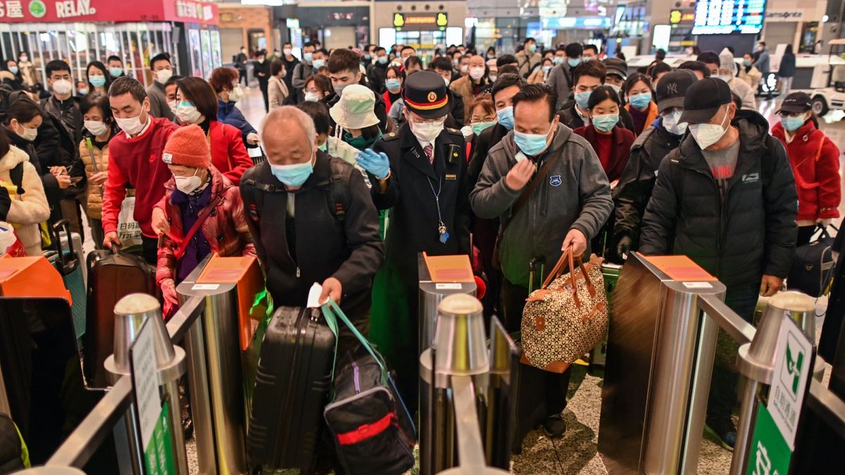 A többi között Vuhanba induló utasok tolonganak a sanghaji pályaudvaron