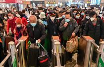 A többi között Vuhanba induló utasok tolonganak a sanghaji pályaudvaron