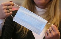 An employee shows a protective face mask on January 28, 2020 at a pharmacy in Kaufbeuren, southern Germany.