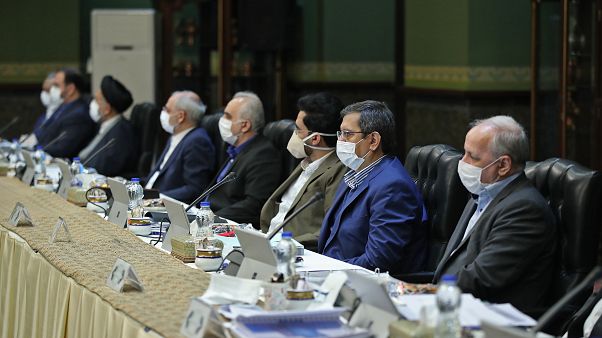 وزراء في الحكومة الإيرانية يستمعون لكلمة الرئيس روحاني وقد وضعوا كمامات واقية بينهم وزير الخارجية محمد جواد ظريف وزراء في الحكومة الإيرانية يستمعون لكلمة الرئيس روحاني وقد وضعوا كمامات واقية بينهم وزير الخارجية محمد جواد ظريف