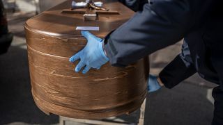 The coffin containing remains of a victim of the COVID-19 is taken for cremation at the Almudena cemetery in Madrid, Spain, Saturday March 28, 2020.