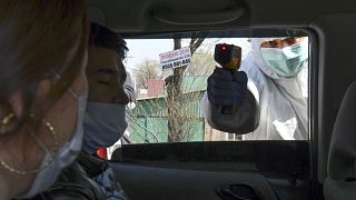 عامل في قطاع الصحة يقيس درجة حرارة راكبي سيارة عند حاجز في بيشكبك عاصمة قرغيزستان - 2020/03/25
