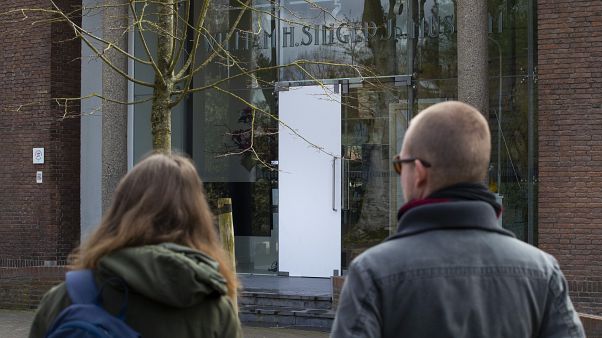 Two people look at the glass door which was smashed during a break-in at the Singer Museum in Laren, Netherlands, Monday March 30, 2020. Two people look at the glass door which was smashed during a break-in at the Singer Museum in Laren, Netherlands, Monday March 30, 2020.
