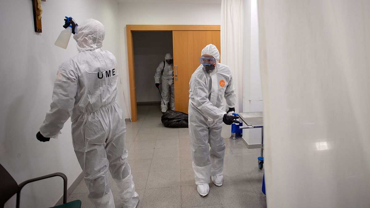 A member of the Military Emergencies Unit (UME) sprays a crucifix as they carry out a general disinfection at the Sant Antoni care facility in Barcelona on March 27, 2020.