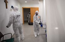 A member of the Military Emergencies Unit (UME) sprays a crucifix as they carry out a general disinfection at the Sant Antoni care facility in Barcelona on March 27, 2020.