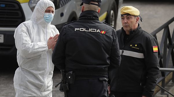 A member of UME, left, talks with a police officer at a ice-skating rink in Madrid, Spain, Tuesday, March 24, 2020. A member of UME, left, talks with a police officer at a ice-skating rink in Madrid, Spain, Tuesday, March 24, 2020.