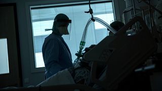 A health worker in the intensive care ward observes a COVID-19 patient at a hospital in Belgium, March 27, 2020. (AP Photo/Francisco Seco, File)