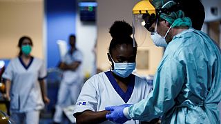 Sanitarios se ponen los equipos de protección antes de trabajar en la unidad para pacientes infectados por el COVID-19 en el Hospital Erasme de Bruselas