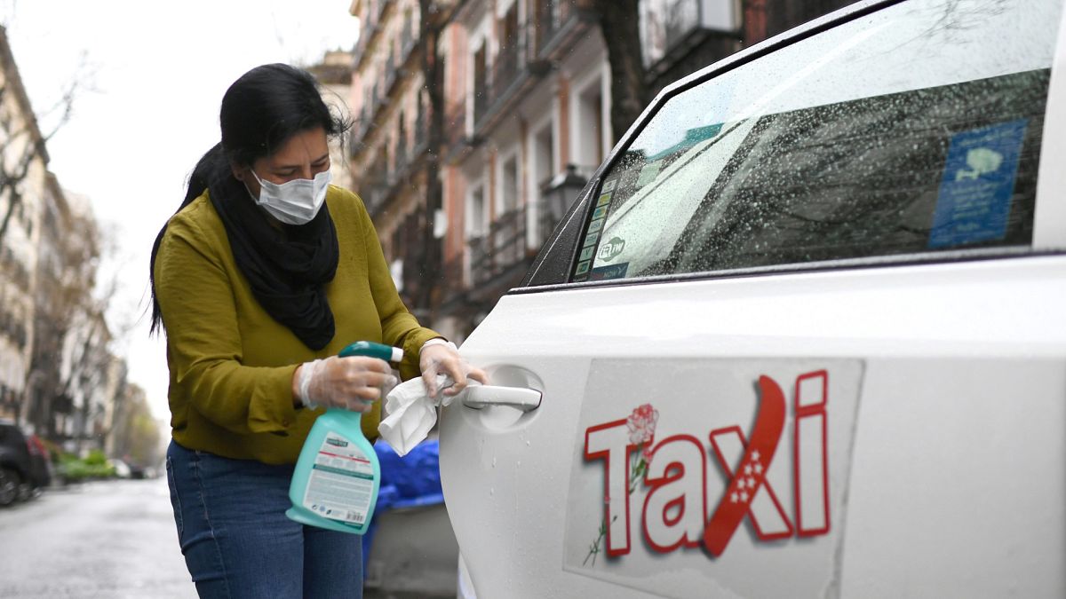 Nuria Castro, chauffeuse de taxi, désinfecte sa voiture à Madrid le 30 mars 2020