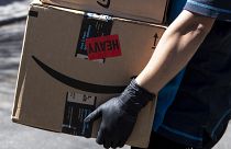 Csomagot visz házhoz az Amazon internetes kereskedelmi cég egyik kiszállítója Los Angelesben 2020. március 26-én.