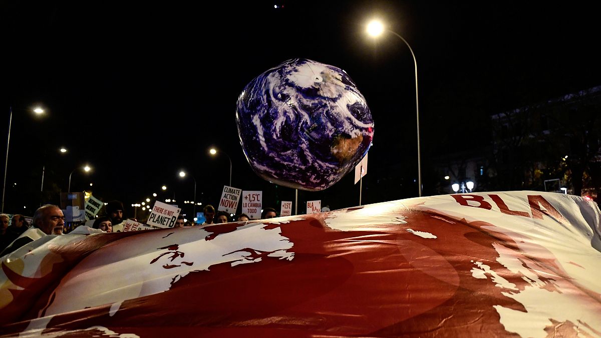 A balloon in the shape of the Earth is pictured during a mass climate protest during the COP25 summit in Madrid, December 6, 2019. (Photo by CRISTINA QUICLER / AFP)