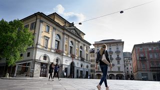People walk in Riforma's square on May 7, 2019 in Lugano, southern Switzerland. (Photo by Fabrice COFFRINI / AFP)
