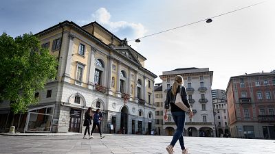 People walk in Riforma's square on May 7, 2019 in Lugano, southern Switzerland. (Photo by Fabrice COFFRINI / AFP)