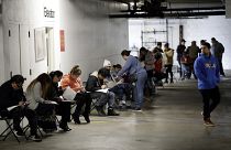 In this March 13, 2020 file photo, unionised hospitality workers wait in line in a basement garage to apply for unemployment benefits in Los Angeles
