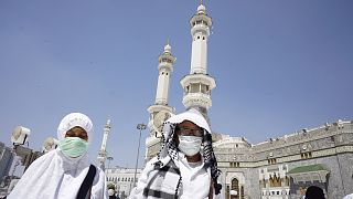 Muslim worshippers wear masks after the noon prayers outside the Grand Mosque, in the Muslim holy city of Mecca, Saudi Arabia