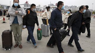 صينيون يحملون حقائبهم متوجيهن إلى مدينة ووهان وسط البلاد