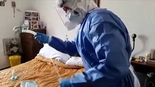 Doctor treating Italian women with coronavirus symptoms at home in Piacenza, Italy