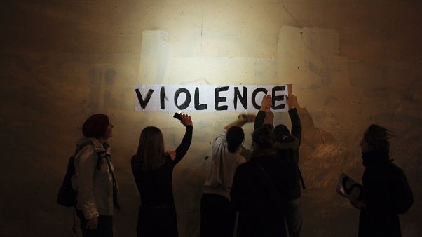 A group of women paste the word "violence" onto a street wall, part of a protest to draw attention to domestic violence, Paris, France, October 2019. A group of women paste the word "violence" onto a street wall, part of a protest to draw attention to domestic violence, Paris, France, October 2019.
