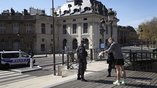 Полицейский проверяет у жителя Парижа разрешение на выход из дома. 