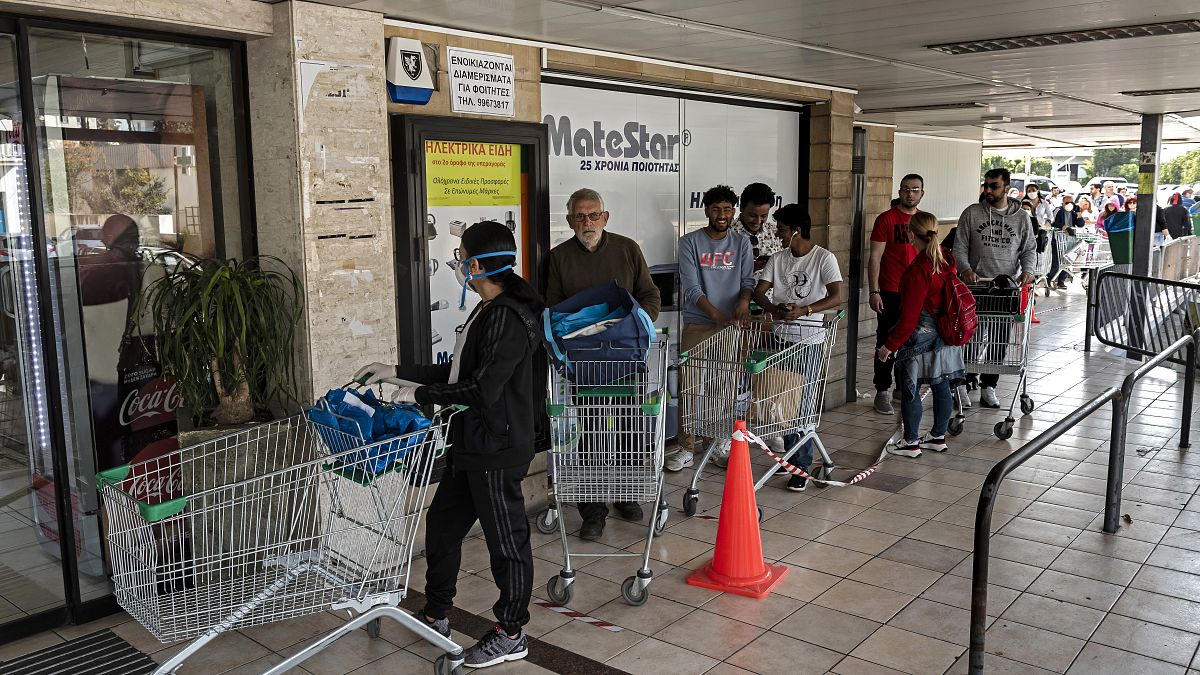 People queue to enter a supermark in Cyprus' capital Nicosia