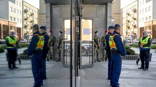 Hungarian policemen and soldiers stand guard at an entrance to the Great Market of Debrecen, Hungary