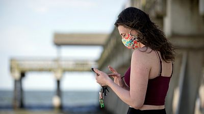 Une femme envoie un message sur son téléphone portable à Tybee Island en Georgie