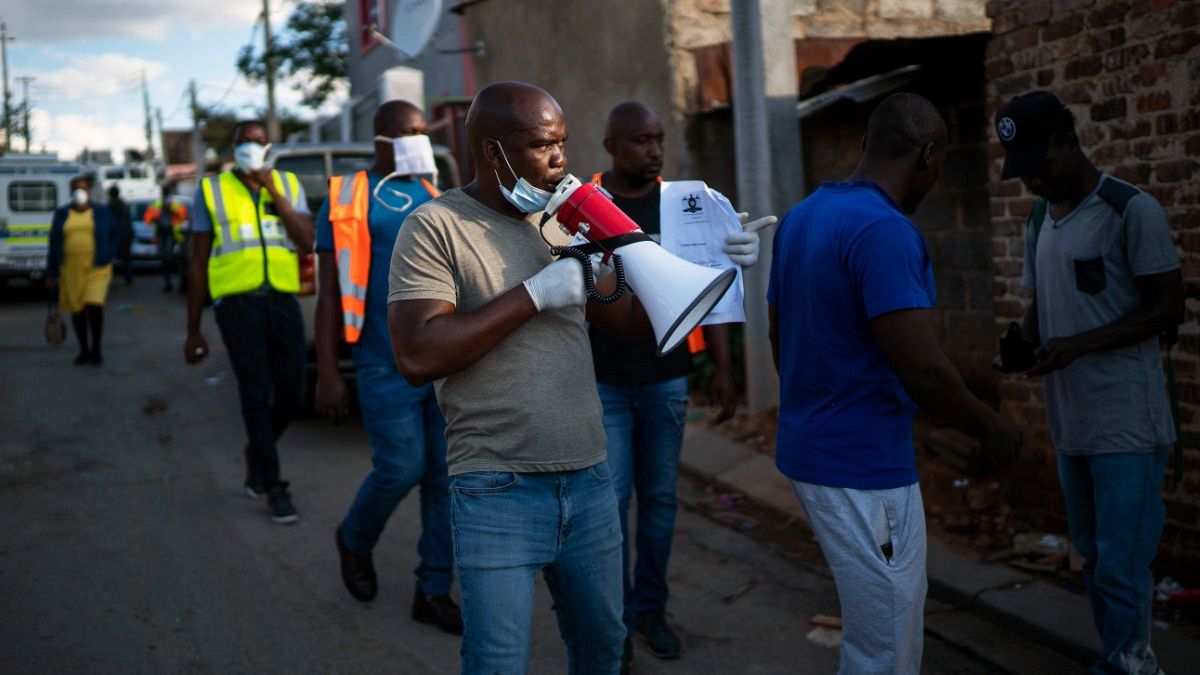 Ativistas comunitários e polícia verificam confinamento anti-Covid-19 na África do Sul