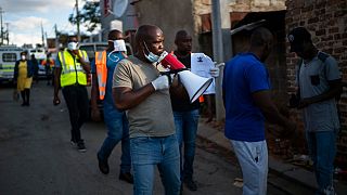 Ativistas comunitários e polícia verificam confinamento anti-Covid-19 na África do Sul
