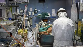 طبيب يعاين مريض مصاب بفيروس كورونا في قسم العناية المركزة لمشفى باسيني قرب ميلانو شمال إيطاليا