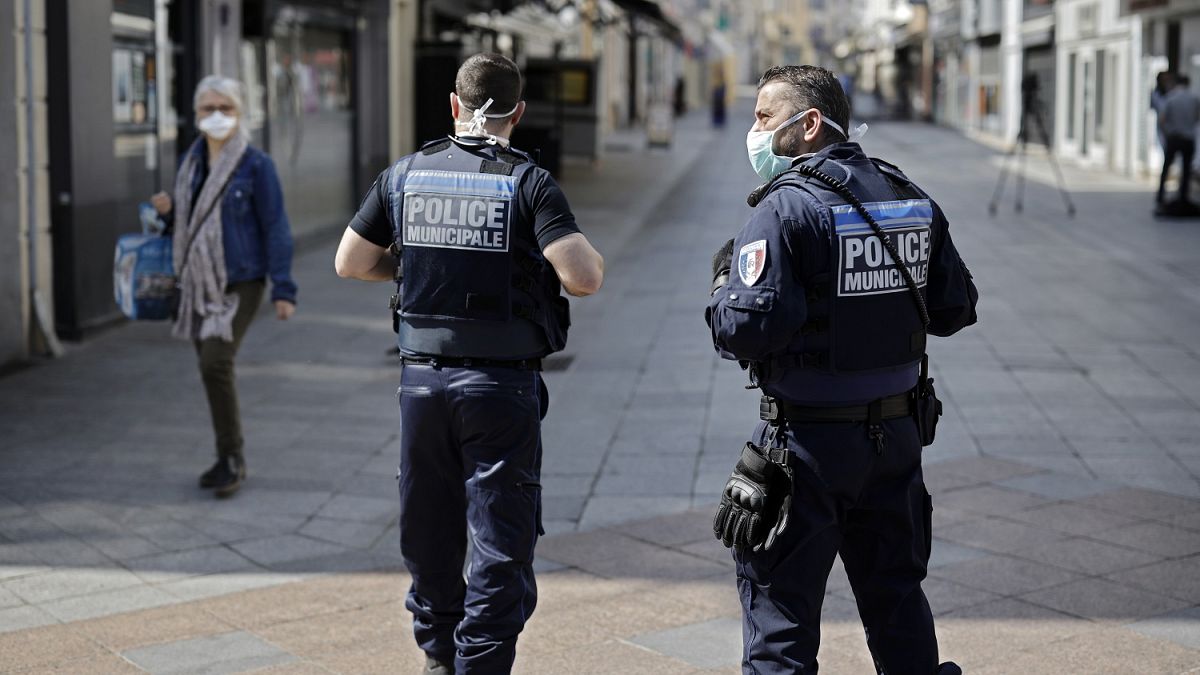 Local police patrol as pedestrians wear face masks in the main street of Sceaux, south of Paris,  on April 8, 2020
