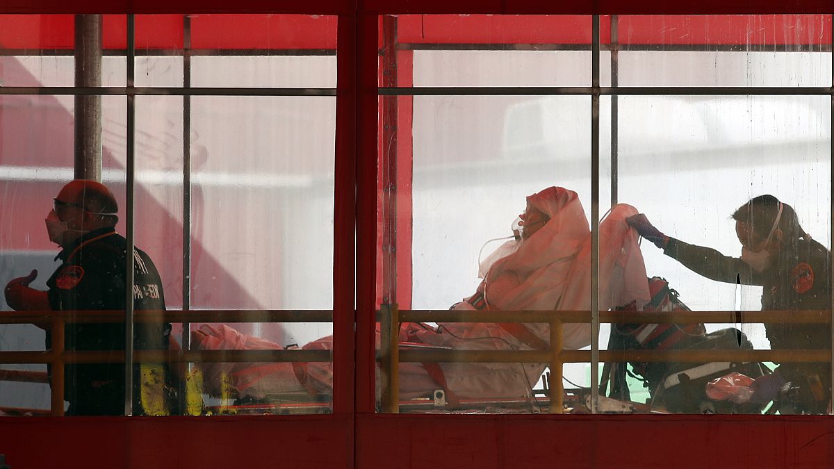 Emergency medical technicians wheel a patient into Elmhurst Hospital Center's emergency room, Tuesday, April 7, 2020