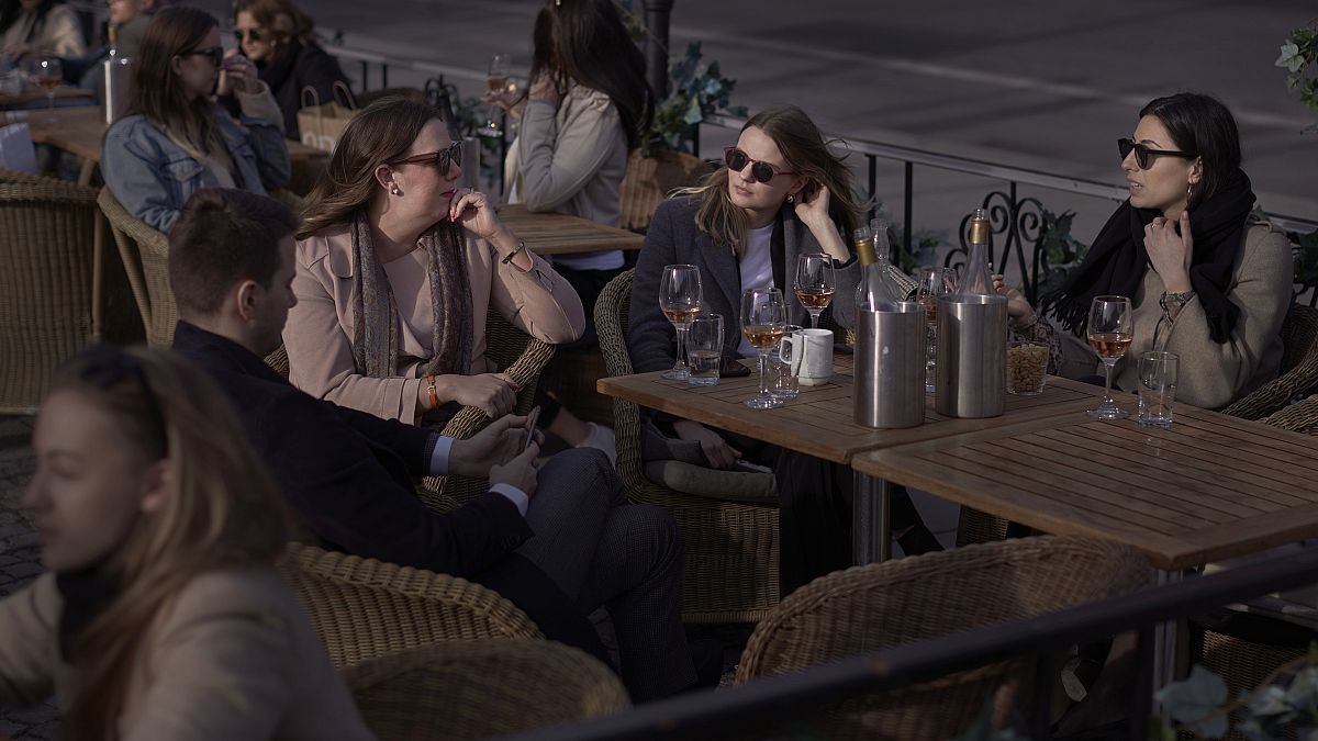 People chat and drink in Stockholm, Sweden, Wednesday, April 8, 2020. 