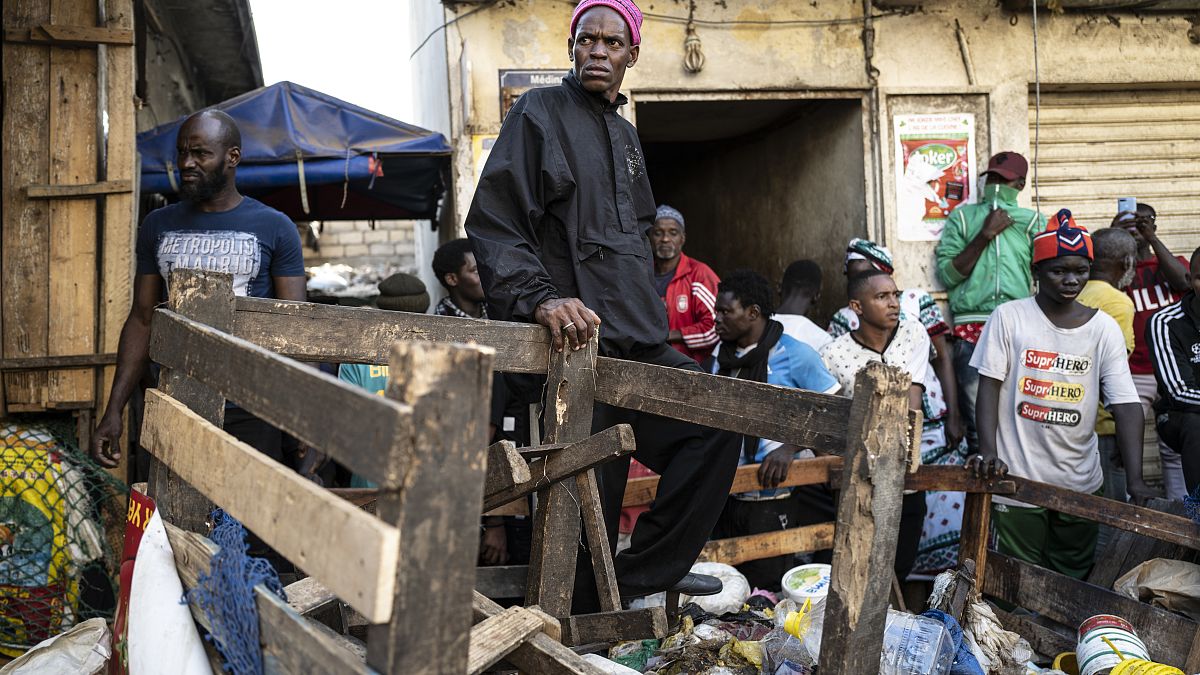 A shopkeeper watches as a bulldozer demolishes informal shops in an effort to stop the spread of the coronavirus, Dakar, Senegal, March 22, 2020.