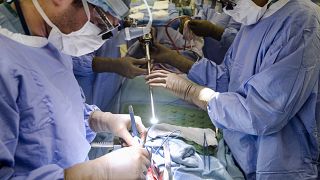 In this Tuesday, Jan. 23, 2018 file photo, a surgeon directs a special camera to be able to view his patient's cancer tumor on monitors while performing surgery at a hospital.