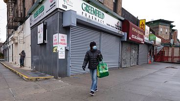 April 3, 2020: a woman walks by local stores during the coronavirus pandemic in New York. 