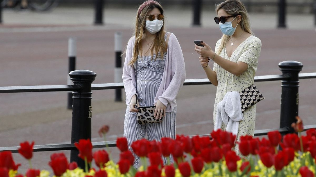 Dos mujeres pasean con máscaras protectiras cerca de Buckingham Palace 