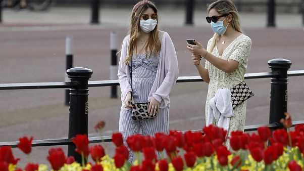 Dos mujeres pasean con máscaras protectiras cerca de Buckingham Palace Dos mujeres pasean con máscaras protectiras cerca de Buckingham Palace