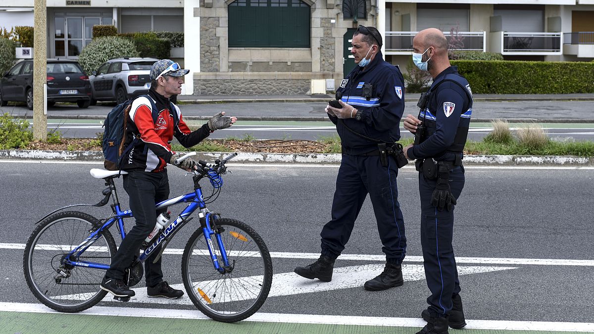 A cyclist is stopped by French police controlling the lockdown at La Baule in western France, Easter Monday, April 13, 2020.