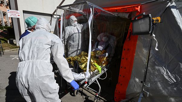 Firefighters exit a patient on a sarcophagus stretcher from a medical tent outside the Montpellier University Hospital which houses a COVID-19 test center on April 14, 2020 Firefighters exit a patient on a sarcophagus stretcher from a medical tent outside the Montpellier University Hospital which houses a COVID-19 test center on April 14, 2020