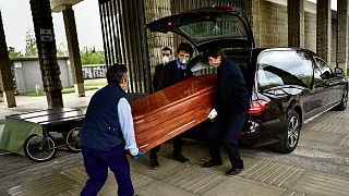 Des agents de pompes funèbres déchargeant un cercueil dans le cimetière San José à Pampelune, dans le nord de l'Espagne, le 13 avril 2020.