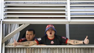 Fans of Independiente de Medellin soccer club - quarantined in Argentina - shout to journalists from a hotel in Buenos Aires, Tuesday, April 14, 2020. 