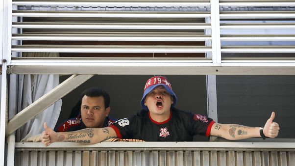 Fans of Independiente de Medellin soccer club - quarantined in Argentina - shout to journalists from a hotel in Buenos Aires, Tuesday, April 14, 2020. 