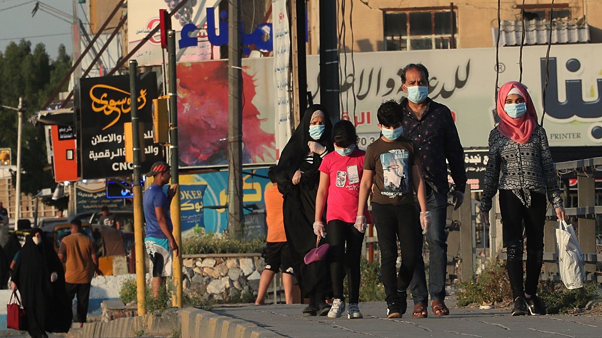 Irak'ın başkenti Bağdat'ta halk, koronavirüs salgınına karşı maskeleriyle dolaşıyor