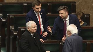 Jaroslaw Kaczynski,left, leader of the conservative ruling party Law and Justice, speaks with other members of his party in parliament in Warsaw, Poland, Friday April 3, 2020