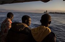 Men who were rescued off the Libyan coast, watch the city of Messina from the deck of the Open Arms rescue vessel as the ship enters the port located on the island of Sicily